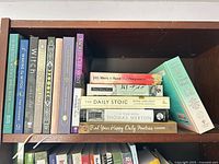 Books arranged on shelf showing spines and stack displaying all 13 titles