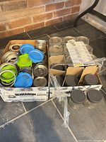 Two Bernardin boxes containing glass jars, assorted metal bands, blue and green plastic lids, grey plastic lids on jars