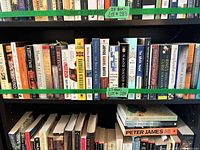 Full shelf view showing two green-taped sections, middle row is 27-book lot