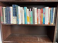 Full shelf view showing entire row of approximately 30 books
