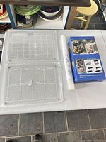 Two acrylic planners in bubble wrap, boxed organizer, rolled liner on table