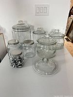 All seven jars with lids and one extra lid arranged on tabletop