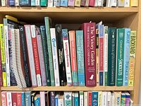 Shelf showing spines of approximately 20-25 mixed gardening and homesteading books