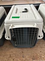 Front view of white and dark gray Essentials hard-sided plastic pet carrier with metal wire door