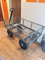 Full view of mesh garden wagon showing steel frame, mesh sides, pneumatic tires, and pull handle