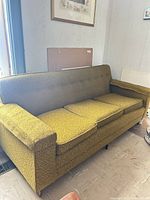 Full front view of sofa, three cushions, button-tufted back