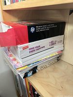 Stack showing HP Premium Choice Laser Paper ream, Staples cover stock ream and additional cover stock pad