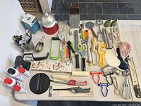 Full table view showing entire assortment of kitchen utensils, tools, sprays and accessories