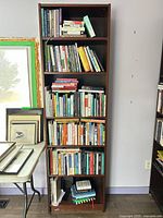 Full view of tall dark brown bookcase filled with books (books not included)
