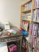 Full view of bookcase filled with books, shows light wood tone and overall size