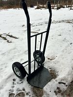 Full view of steel hand truck standing on snow