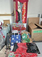 Overall lot showing Rubbermaid organizer, wrapping paper rolls, gift bags, tissue pack, bulk bows