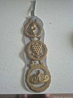 Full view of leather strap with three horse brasses attached