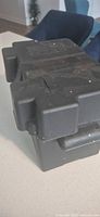 Angle view of entire black plastic battery box showing lid and body