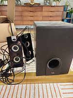 Full set showing two satellite speakers with wiring and subwoofer