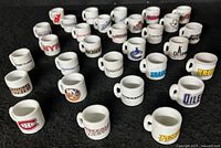 Front angled view of 30 miniature white mugs showing various NHL team logos