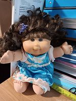 Front view of Cabbage Patch Kids doll seated