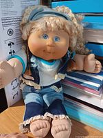 Full view of 16-inch blond Cabbage Patch Kids doll sitting on desk