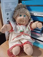 Full view of Cabbage Patch Kids doll seated showing overall condition and outfit