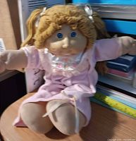 Full view of doll seated showing dress and hair