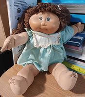 Full view of doll seated showing size and clothing