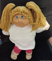 Front view of 1985 Cabbage Patch Kids doll seated, showing hair, eyes, outfit