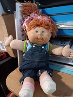 Full view of doll sitting upright showing outfit and size perspective