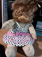 Front view of doll seated showing full outfit and features