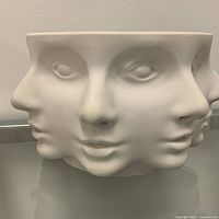 Front view of white porcelain bowl showing three abstract faces