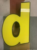 Front view of yellow marquee letter upright as "d"