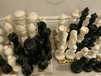 Group of black and white oversized chess pieces, two styles visible