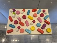 Top view showing full arrangement of multicoloured pills on white base