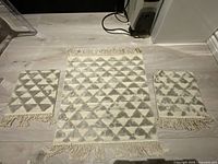 Three tufted mats laid out showing size difference and pattern