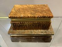 Smaller yellow-brown marble box set atop larger green-brown marble box