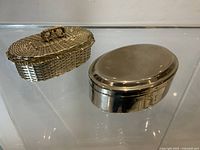 Rectangular woven silvertone box and oval smooth silvertone box, lids closed