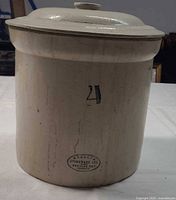 Front view showing crock with lid and blue maker’s stamp