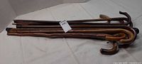 Stack of eight canes showing handles and shafts