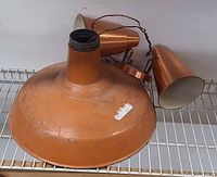 Single broad copper-tone shade and dual spotlight fixture together