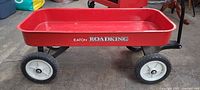 Side view of Eaton Roadking red metal wagon showing full profile, wheels, and logo