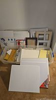 Overview of tote with canvases, mat boards, pads, frame