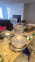 Countertop view of assorted bakeware including round pans, tube pan, pie pans and square pans