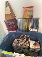 Bin of assorted music CDs and boxed media sets