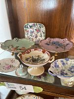 Group of six assorted candy dishes displayed in cabinet