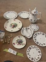 All items laid out including coffee pot, divided dish, five plates, two Old Foley plates, brass posts, screws