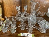 Group view of crystal items: decanter, baskets, bowl, candle holder, champagne glasses, sugar bowl, citrus reamer