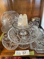 Multiple cut crystal serving pieces arranged on shelf