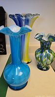 Three coloured glass vases grouped together
