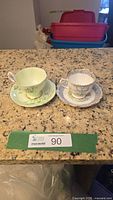 Both teacup and saucer sets side by side on countertop