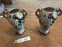 Pair of matching German floral porcelain vases on carpet