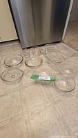 All glass cookware and bakeware pieces laid out together on floor